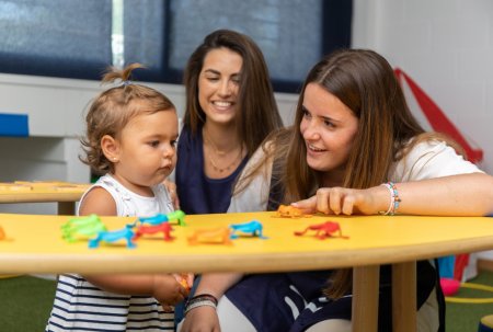 Estudiantes de Medac haciendo prácticas con niña pequeña